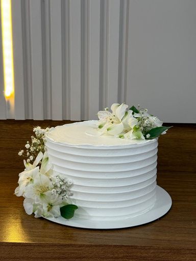 Bolo artesanal branco decorado com flores naturais