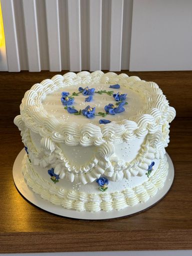 Bolo vintage branco com bico de confeitar e flores azuis